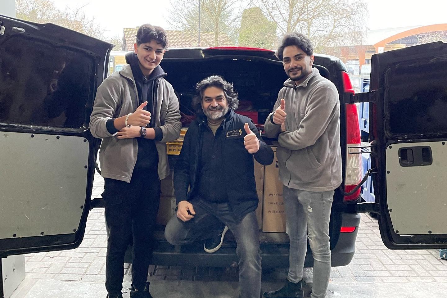 Osman Avcı met twee medewerkers bij de volgeladen bus in Ermelo